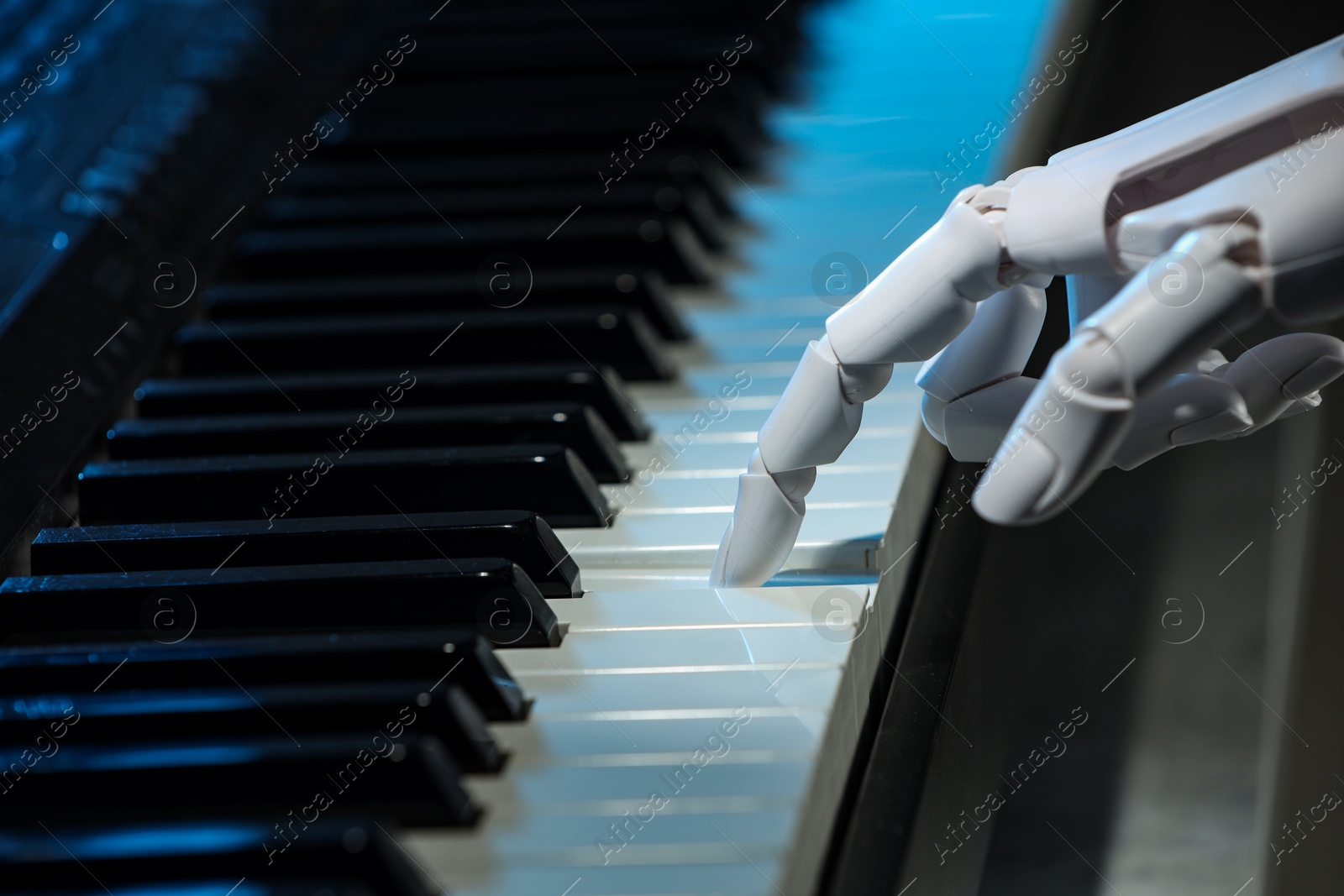 Photo of Artificial intelligence. Robot hand playing piano, closeup