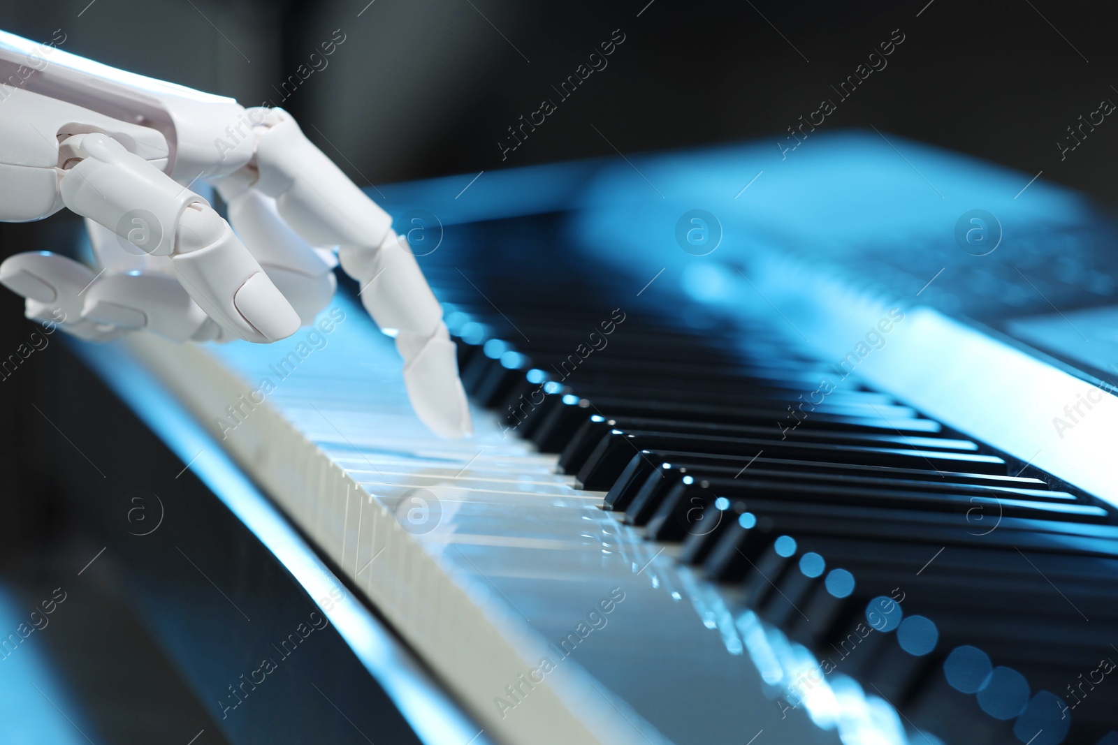 Photo of Artificial intelligence. Robot hand playing piano on dark background, closeup