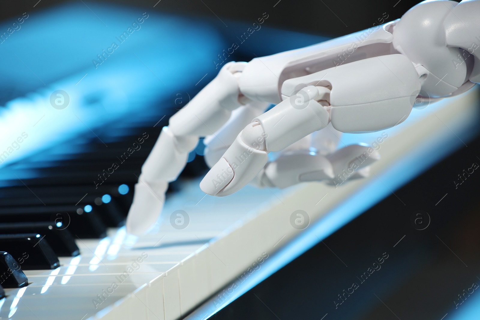 Photo of Artificial intelligence. Robot hand playing piano on dark background, closeup