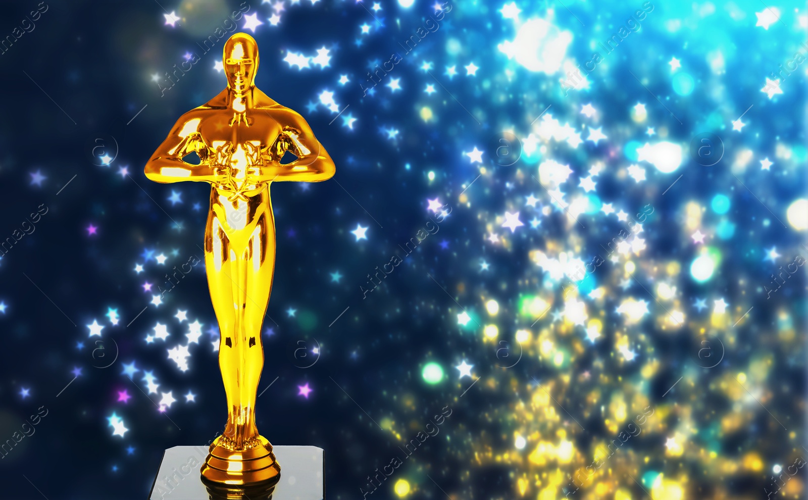 Image of Golden trophy in shape of human figure against shimmering background