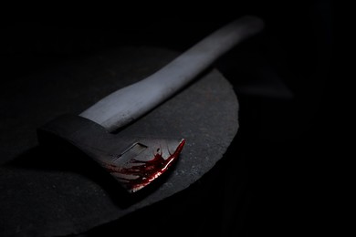 Image of Axe with blood on rusty metal surface in darkness, closeup