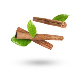 Image of Cinnamon sticks and green leaves in air on white background