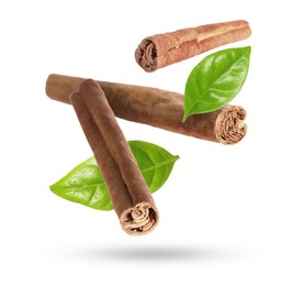 Image of Cinnamon sticks and green leaves in air on white background