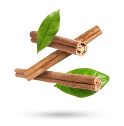 Image of Cinnamon sticks and green leaves in air on white background