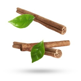 Image of Cinnamon sticks and green leaves in air on white background