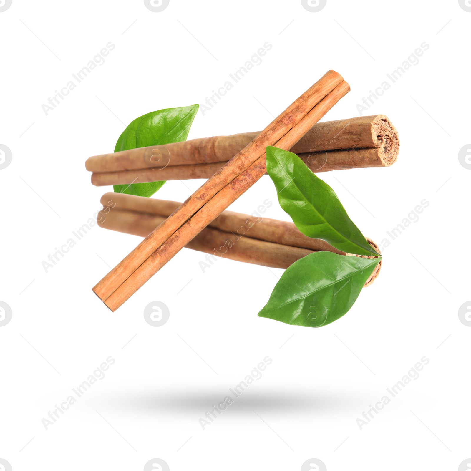 Image of Cinnamon sticks and green leaves in air on white background