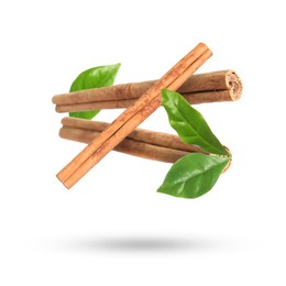 Image of Cinnamon sticks and green leaves in air on white background