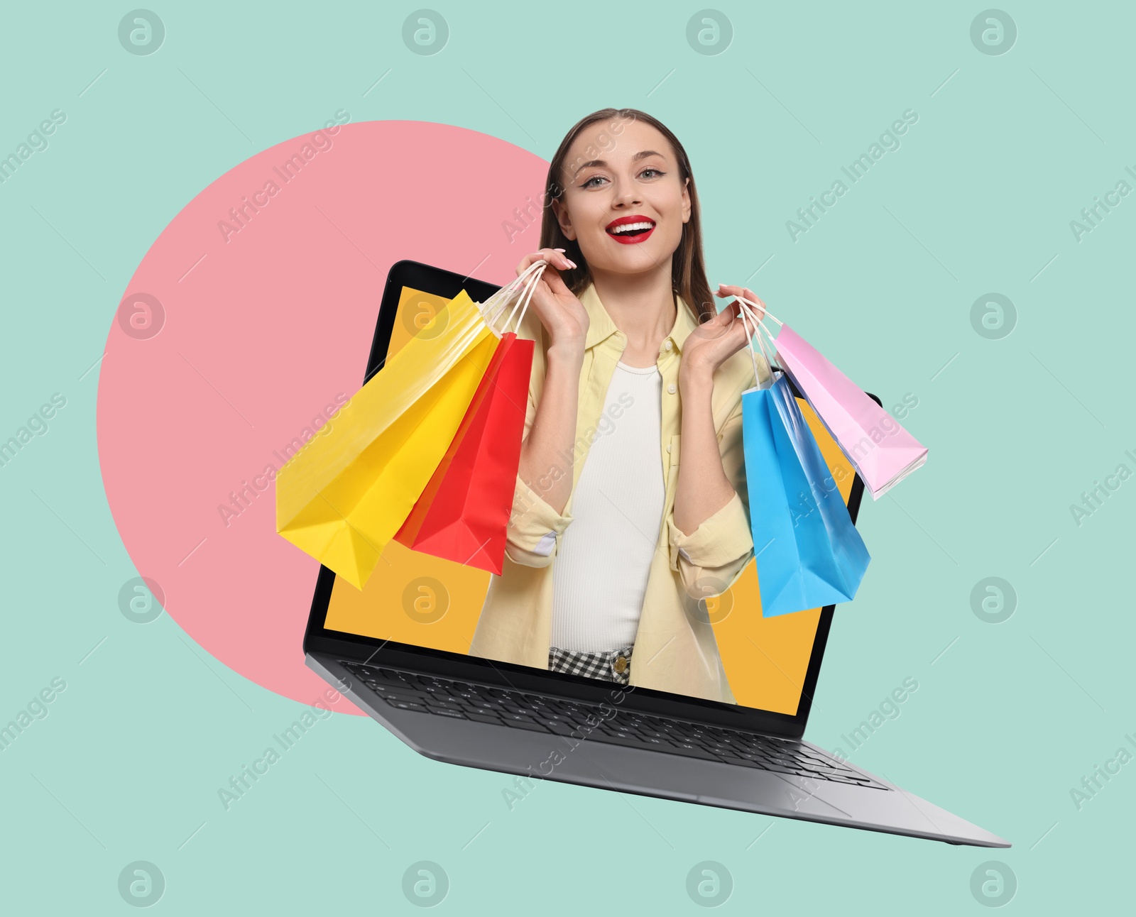 Image of Internet shopping. Happy woman with shopping bags coming out of laptop on color background