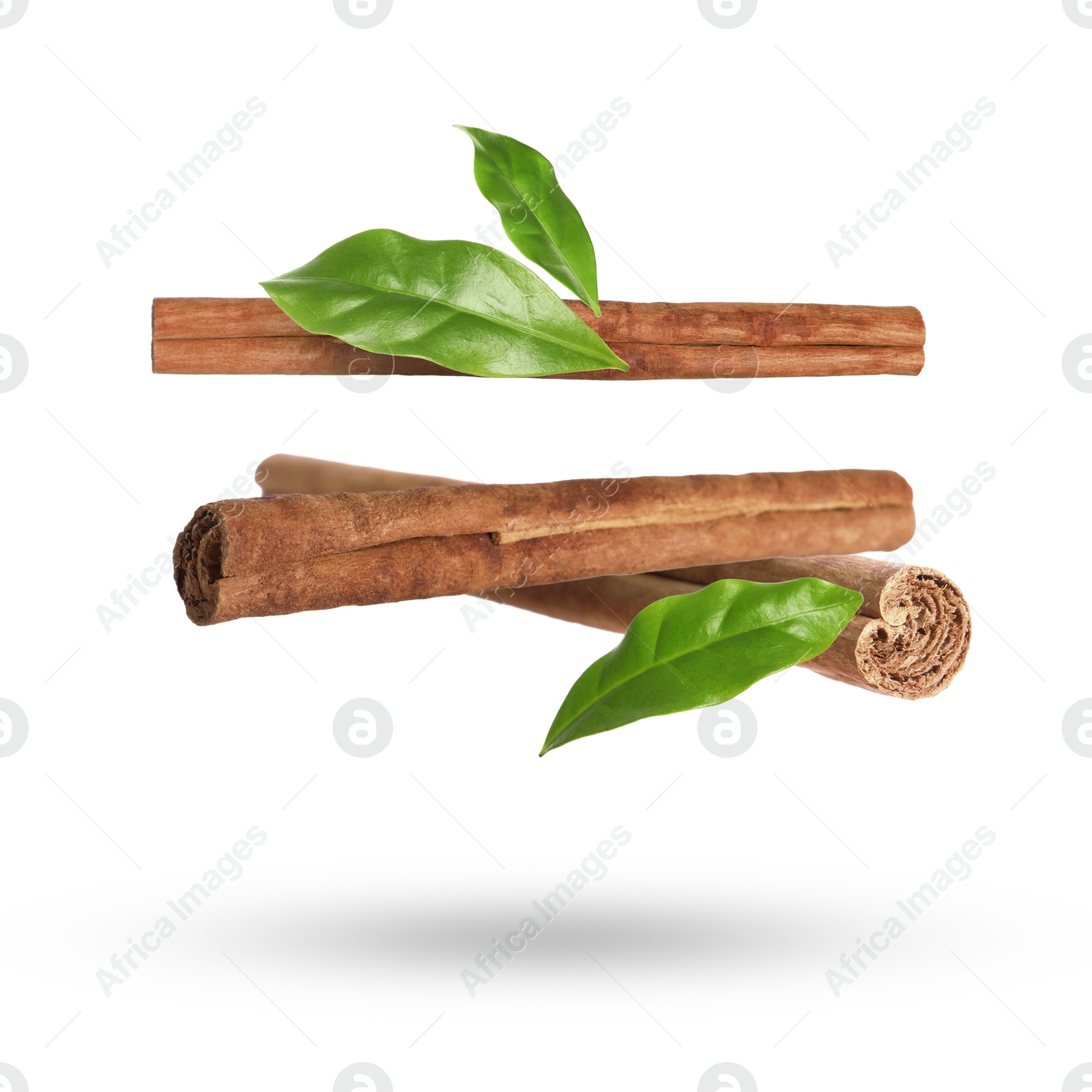 Image of Cinnamon sticks and green leaves in air on white background