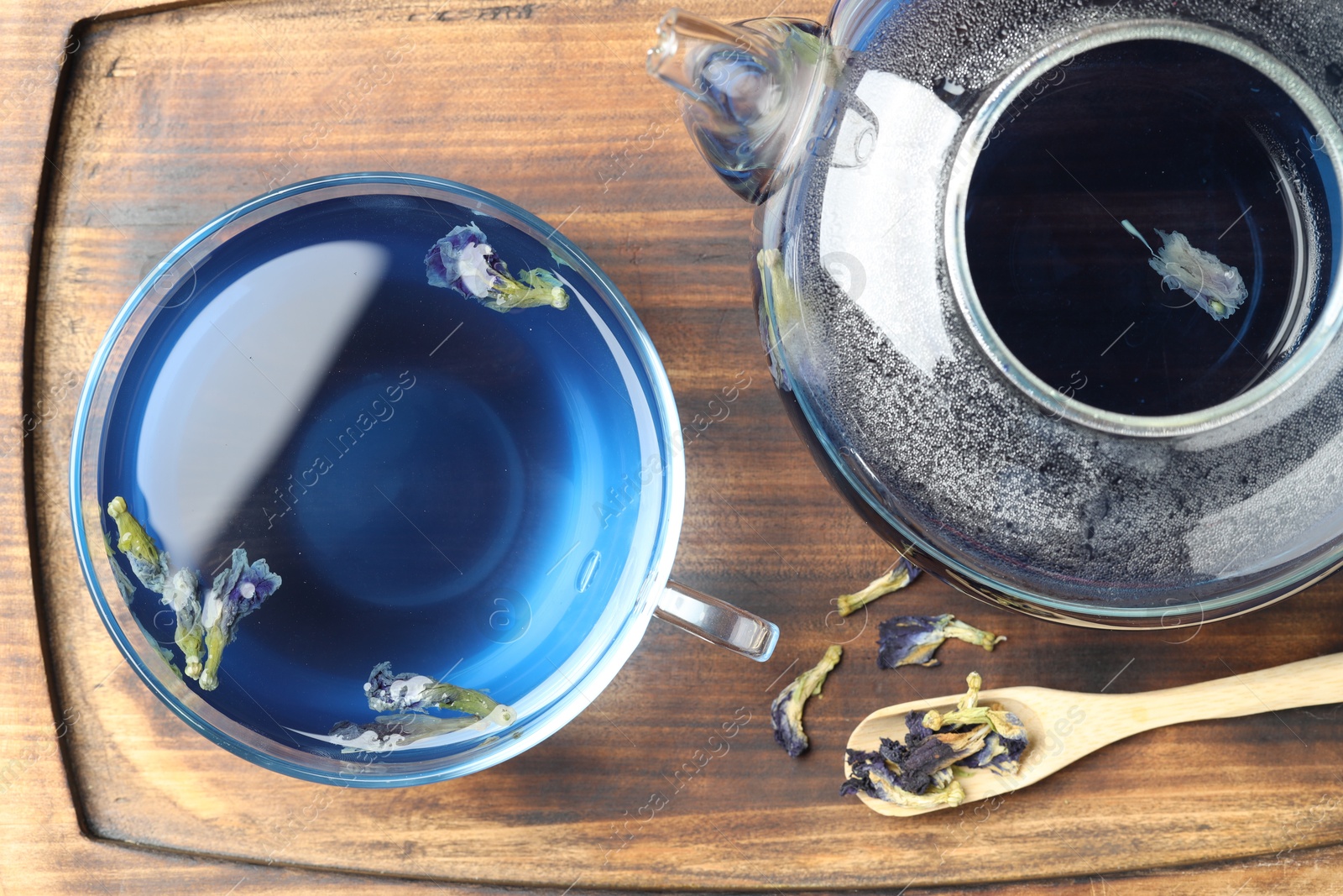 Photo of Delicious butterfly pea flower tea on wooden table, top view