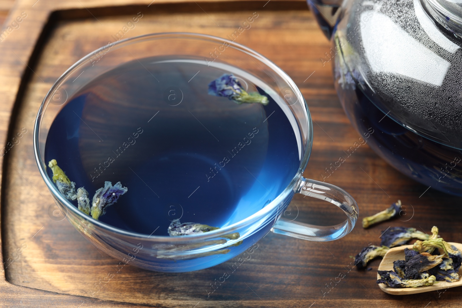 Photo of Delicious butterfly pea flower tea on wooden table, closeup