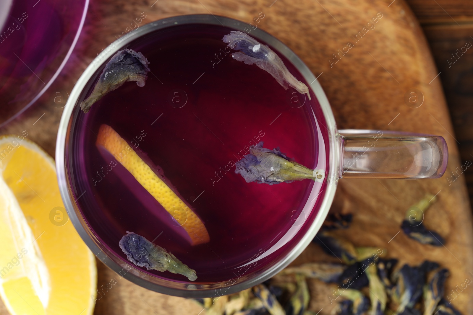 Photo of Delicious butterfly pea flower tea with lemon on table, top view