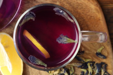 Photo of Delicious butterfly pea flower tea with lemon on table, top view