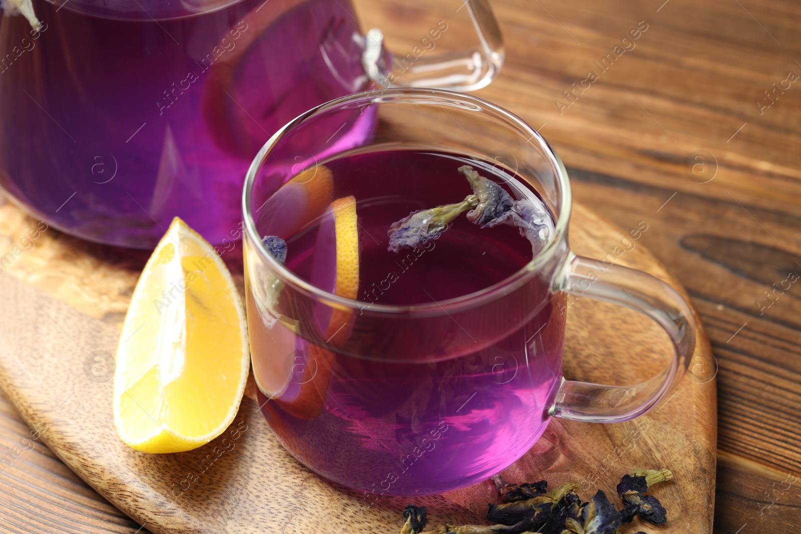 Photo of Delicious butterfly pea flower tea with lemon on wooden table, closeup