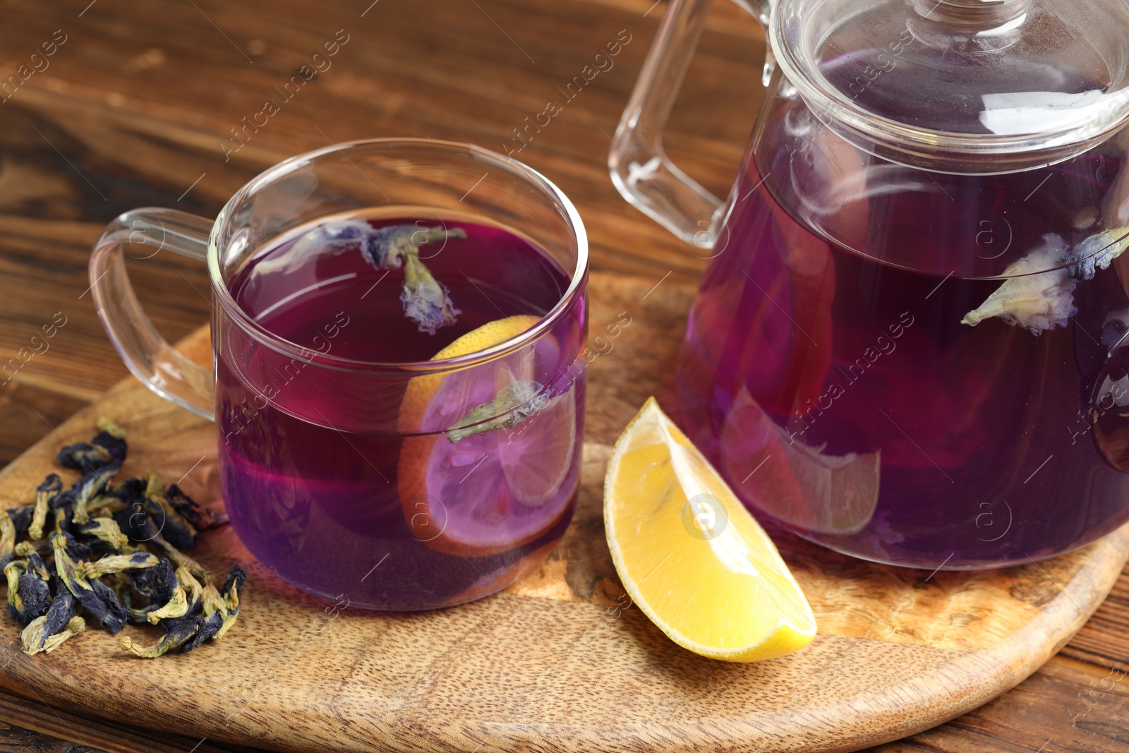 Photo of Delicious butterfly pea flower tea with lemon on wooden table, closeup