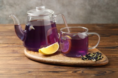 Photo of Delicious butterfly pea flower tea with lemon on wooden table