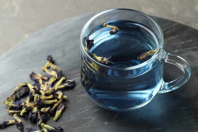 Photo of Delicious butterfly pea flower tea on gray table, closeup