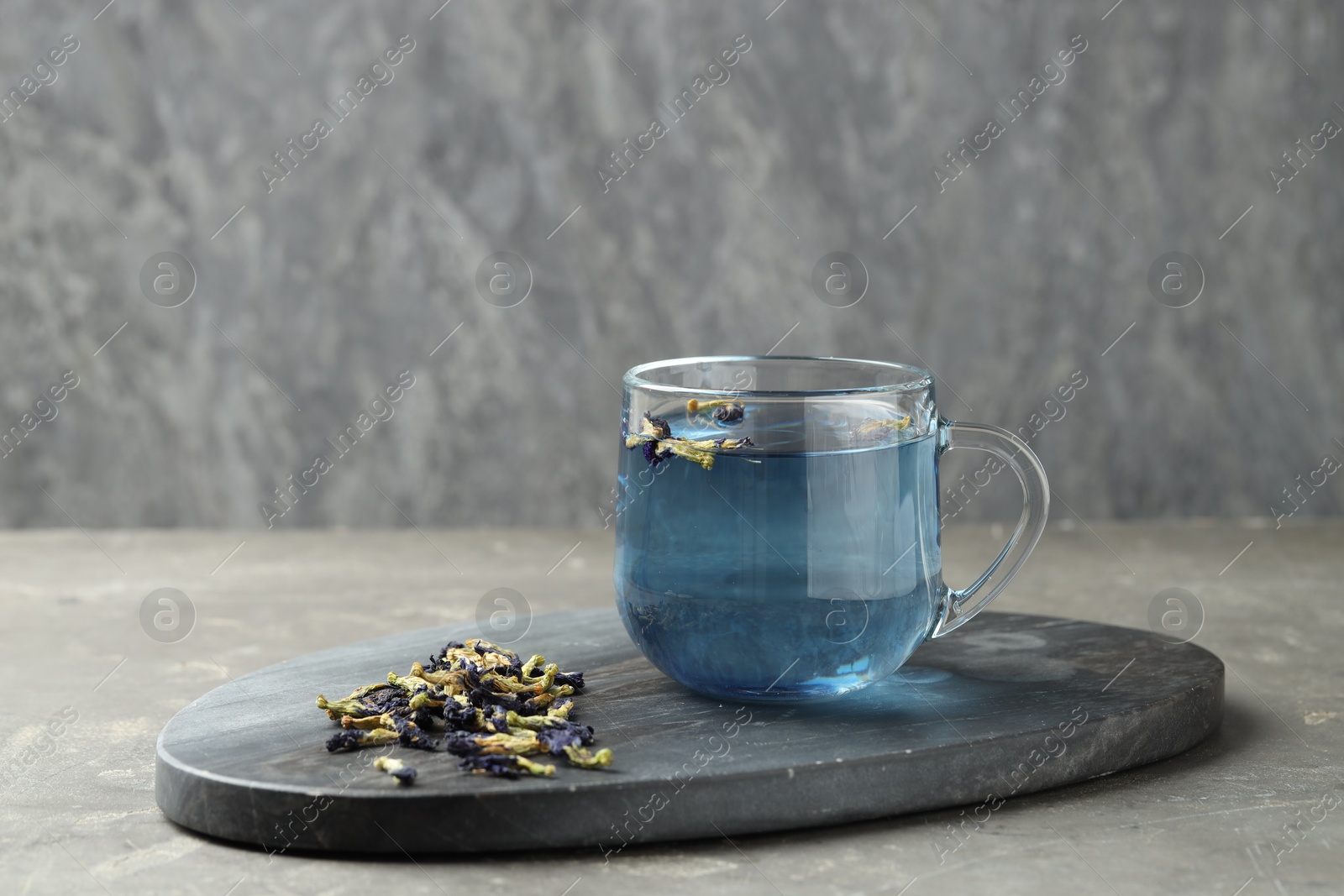 Photo of Delicious butterfly pea flower tea on gray textured table