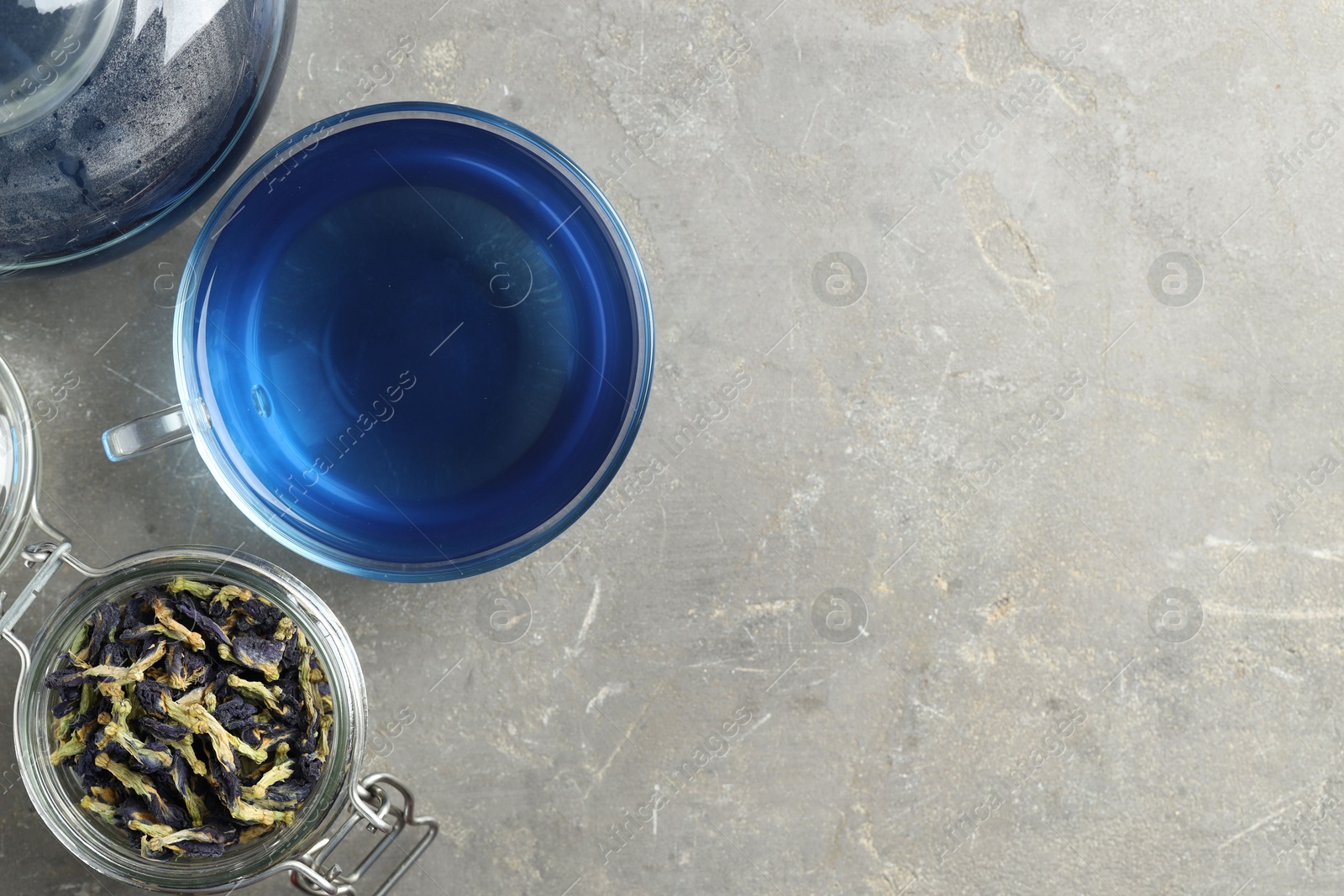 Photo of Delicious butterfly pea flower tea on gray textured table, flat lay. Space for text