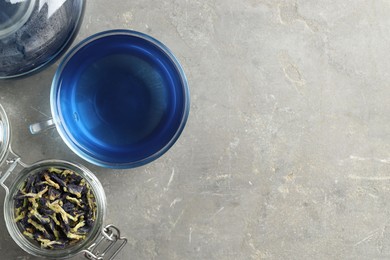 Photo of Delicious butterfly pea flower tea on gray textured table, flat lay. Space for text