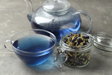 Photo of Delicious butterfly pea flower tea on gray textured table, closeup