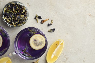 Photo of Delicious butterfly pea flower tea with lemon on gray textured table, flat lay. Space for text