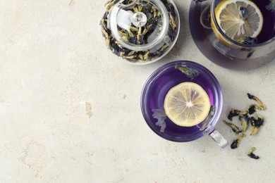 Photo of Delicious butterfly pea flower tea with lemon on gray textured table, flat lay. Space for text