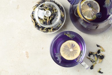 Photo of Delicious butterfly pea flower tea with lemon on gray textured table, flat lay. Space for text