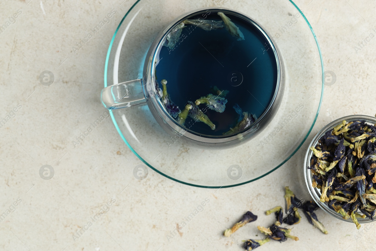 Photo of Delicious butterfly pea flower tea on gray textured table, flat lay. Space for text