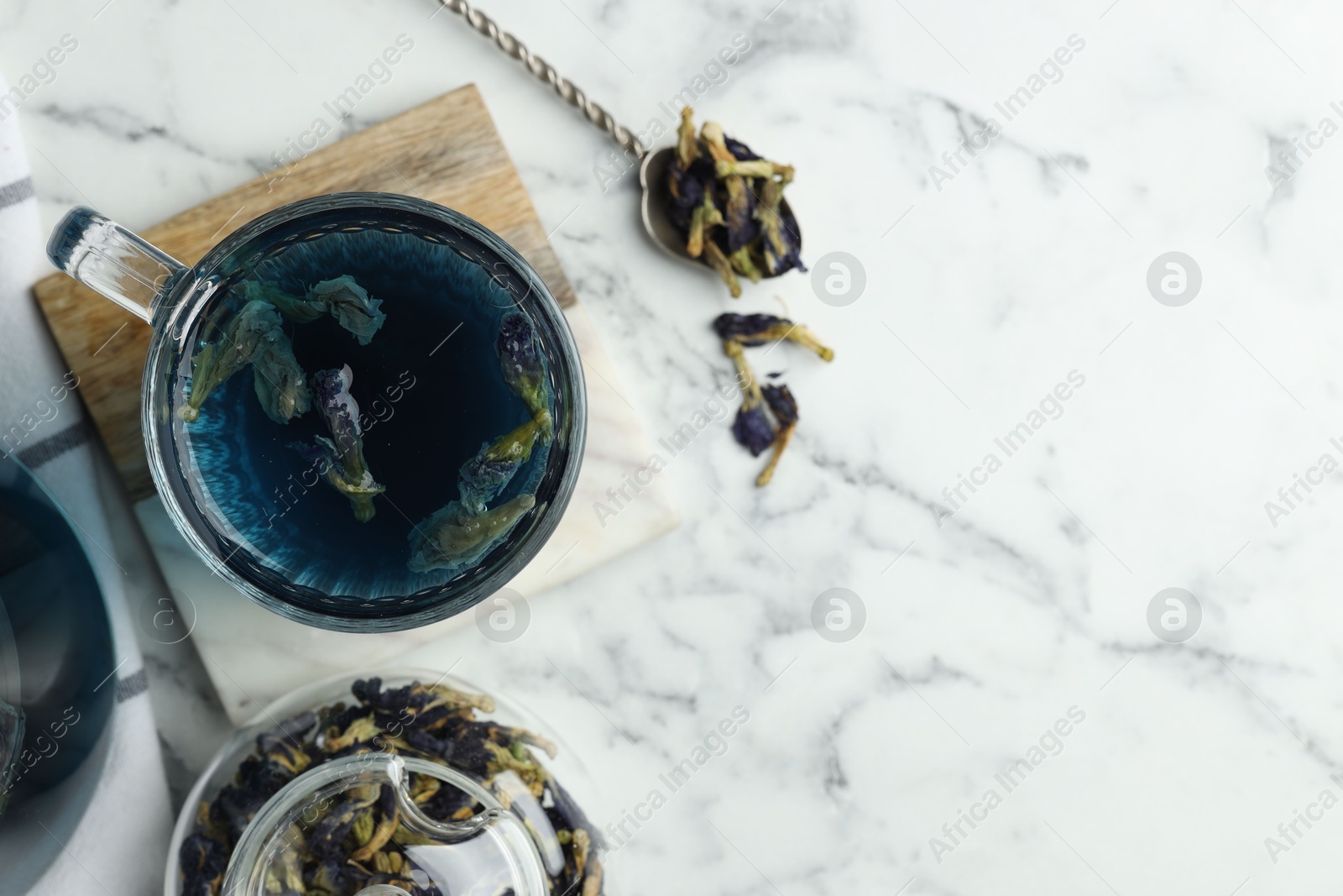 Photo of Delicious butterfly pea flower tea on white marble table, flat lay. Space for text