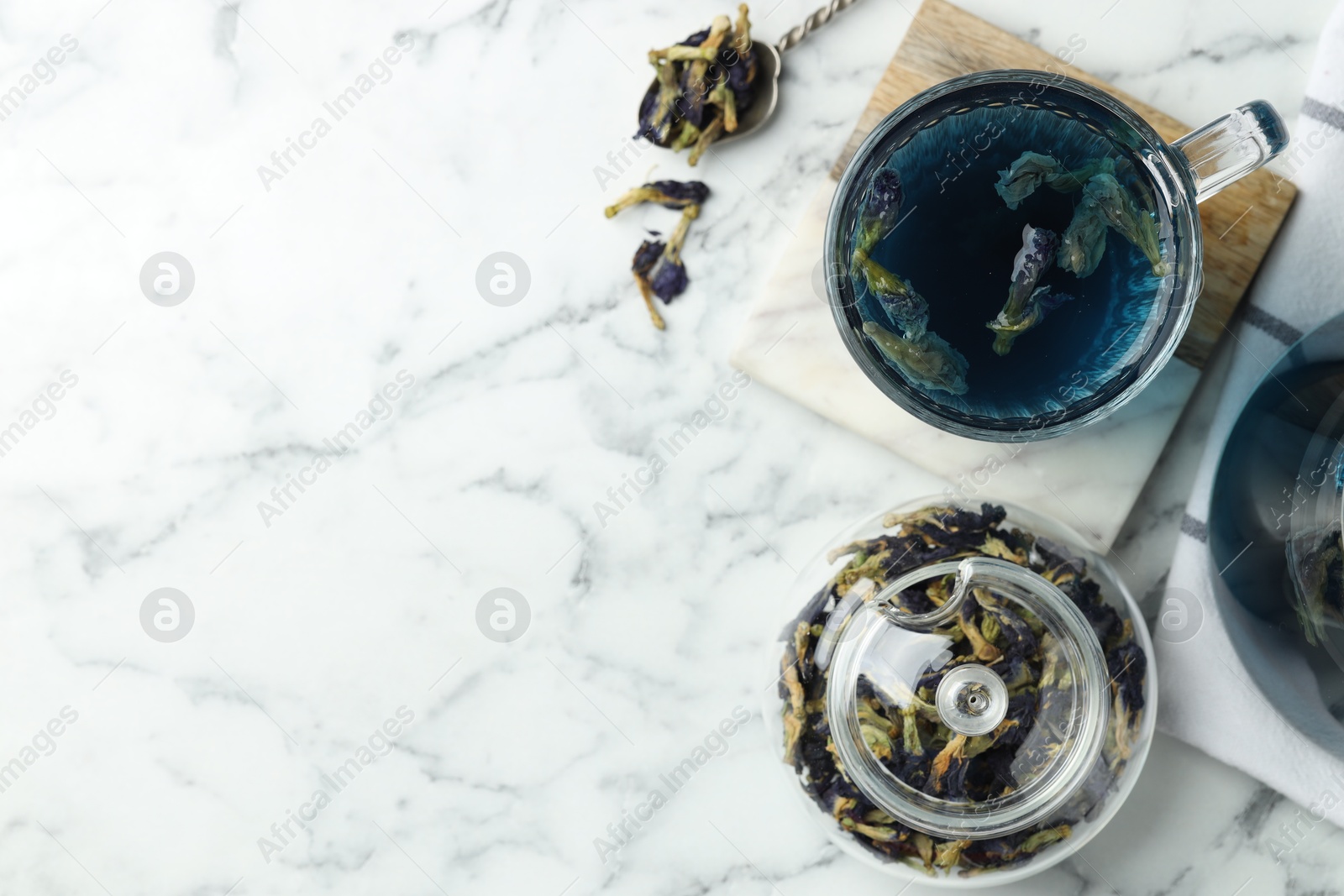 Photo of Delicious butterfly pea flower tea on white marble table, flat lay. Space for text