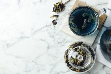 Photo of Delicious butterfly pea flower tea on white marble table, flat lay. Space for text