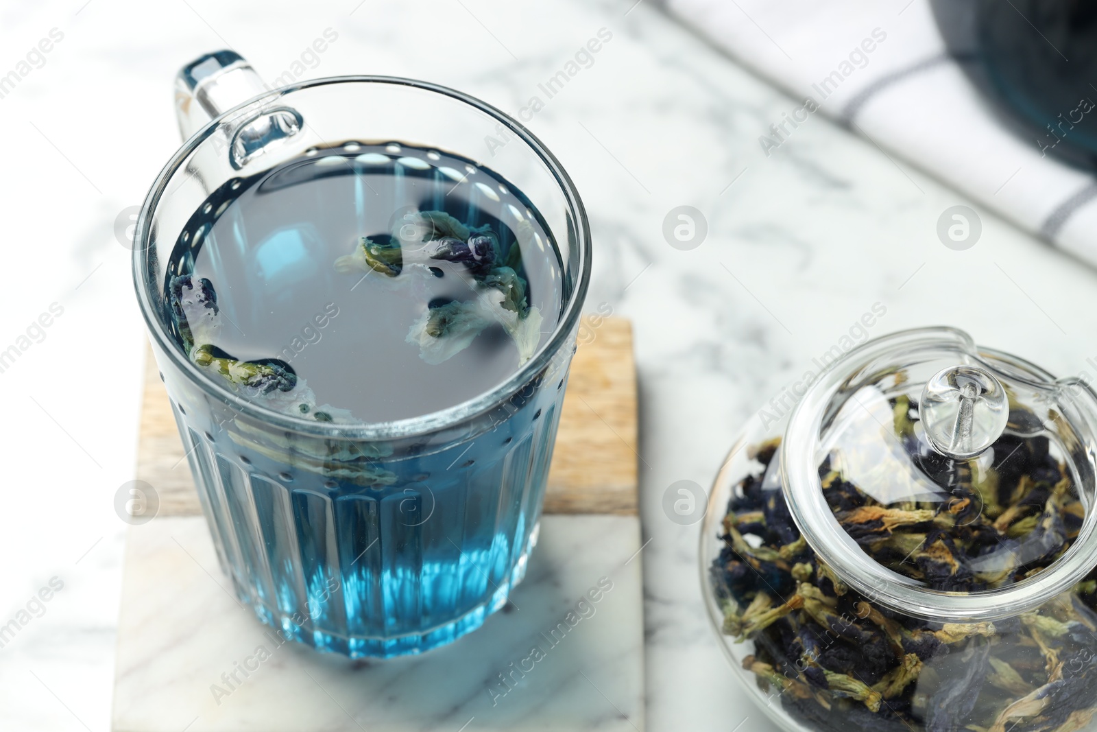 Photo of Delicious butterfly pea flower tea on white marble table, closeup