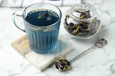 Photo of Delicious butterfly pea flower tea on white marble table, closeup