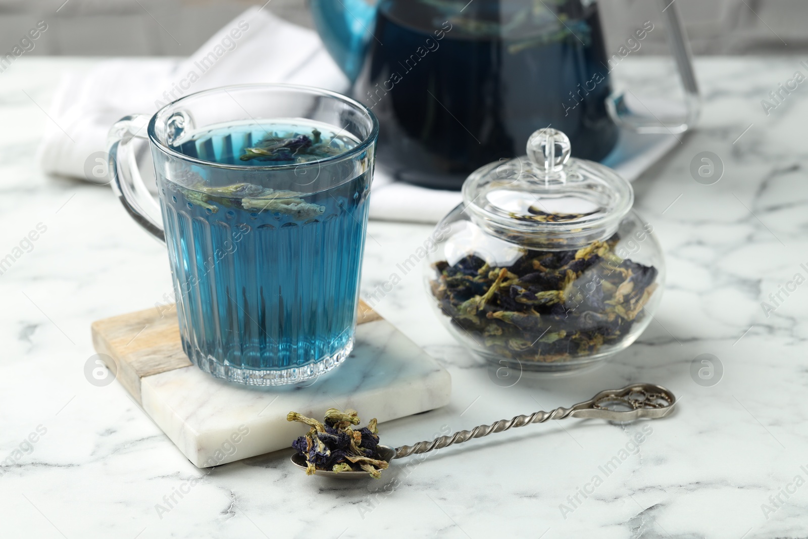 Photo of Delicious butterfly pea flower tea on white marble table