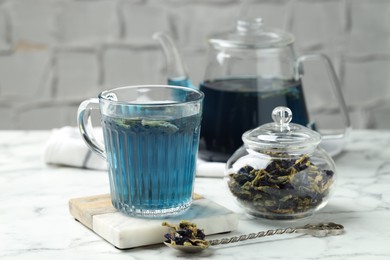 Photo of Delicious butterfly pea flower tea on white marble table