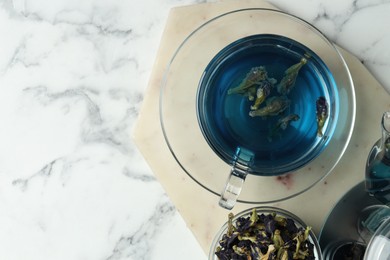 Photo of Delicious butterfly pea flower tea on white marble table, top view. Space for text