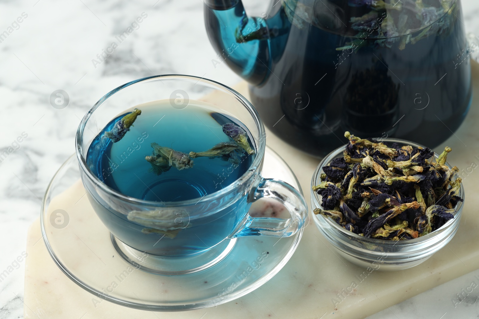 Photo of Delicious butterfly pea flower tea on white marble table, closeup