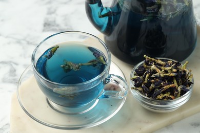 Photo of Delicious butterfly pea flower tea on white marble table, closeup