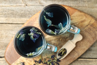 Photo of Delicious butterfly pea flower tea on wooden table, top view