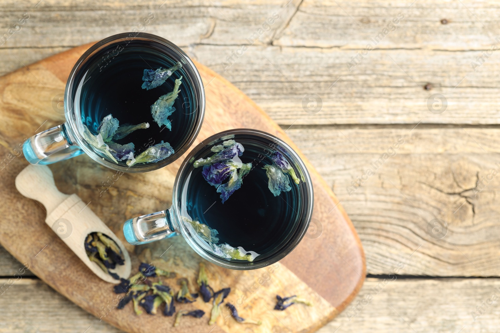 Photo of Delicious butterfly pea flower tea on wooden table, top view. Space for text