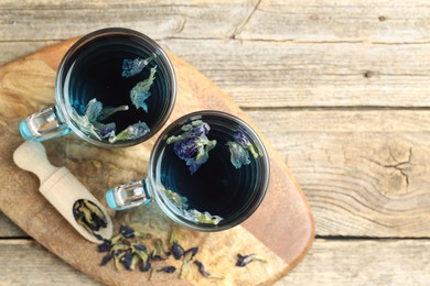 Photo of Delicious butterfly pea flower tea on wooden table, top view. Space for text