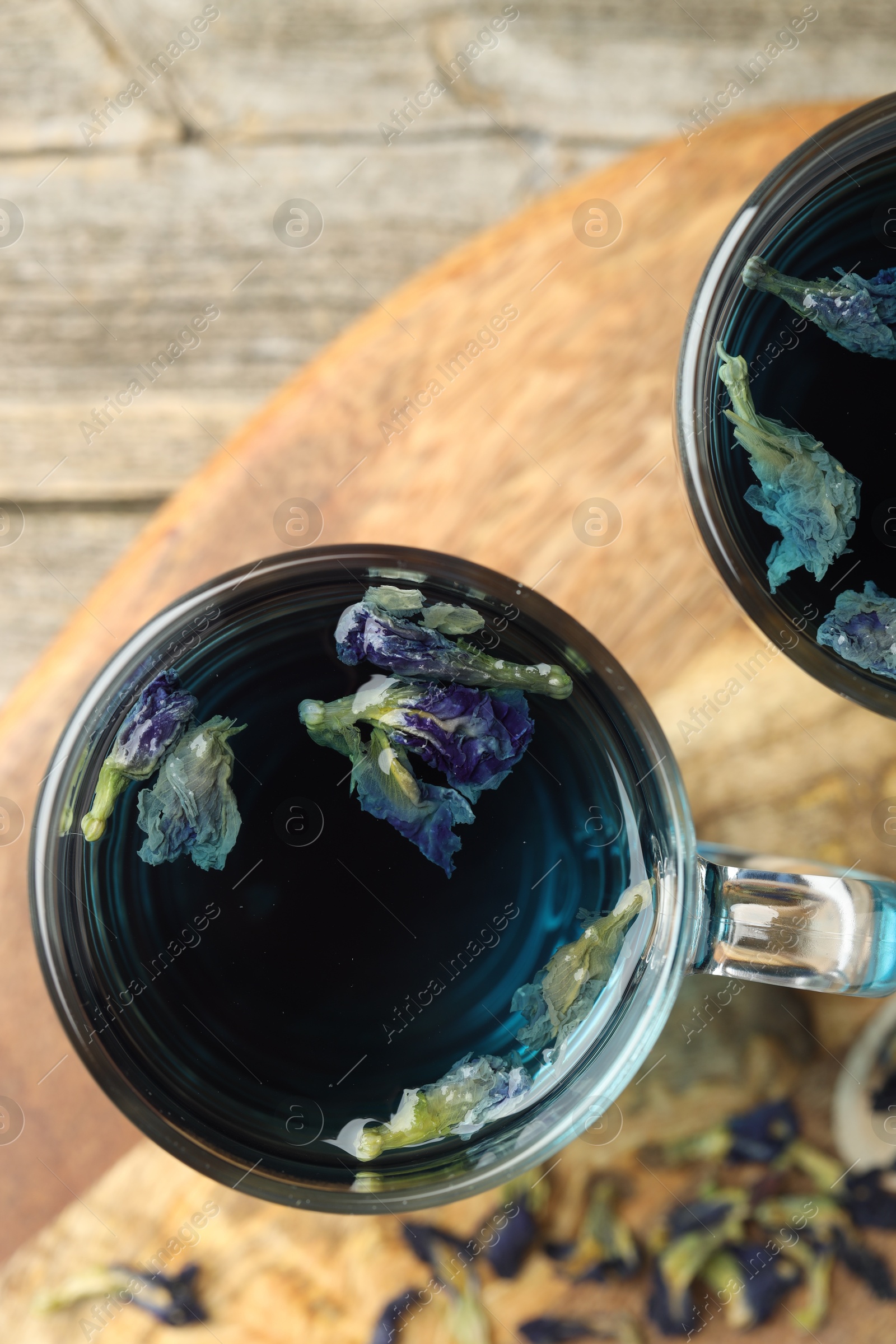 Photo of Delicious butterfly pea flower tea on wooden table, top view