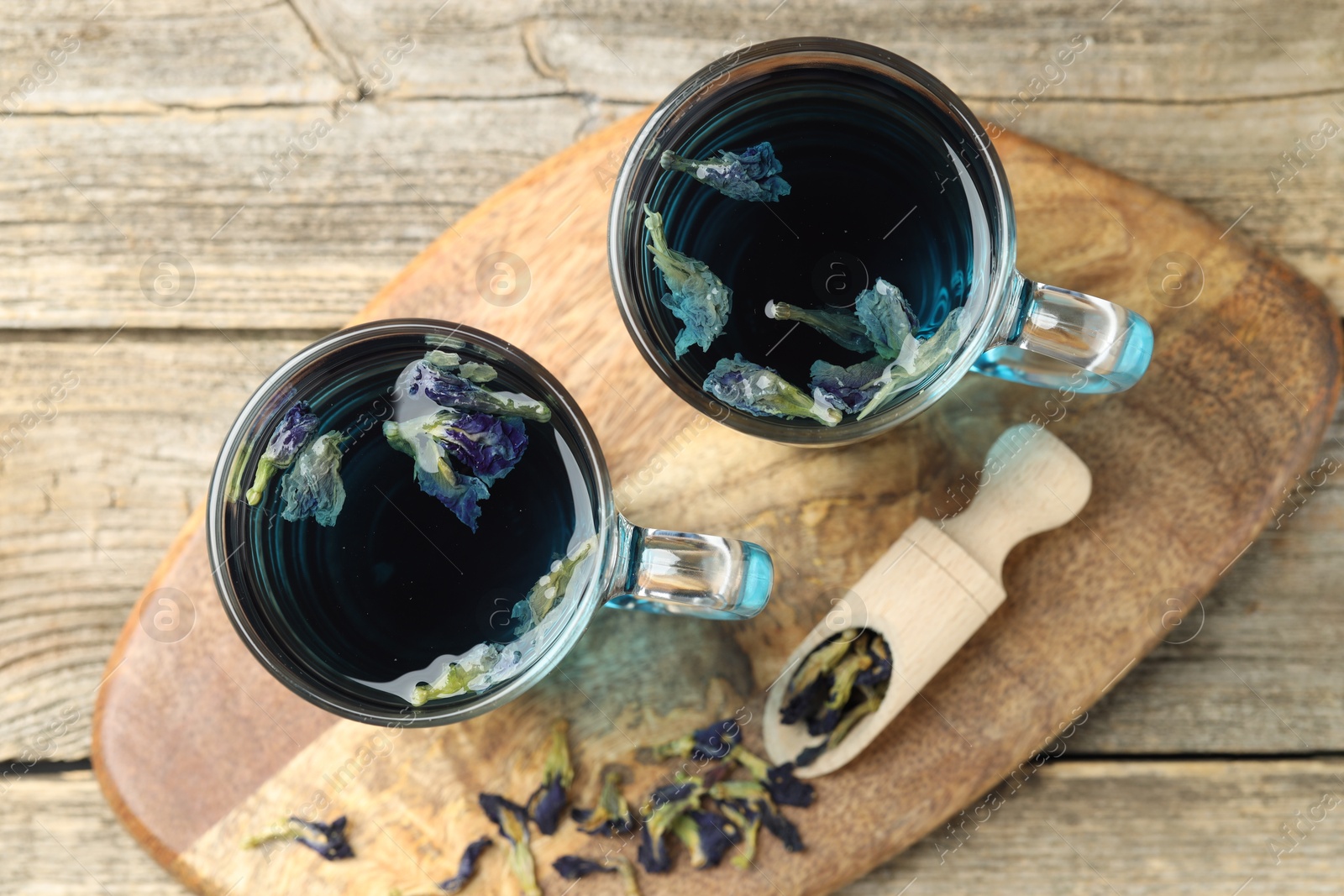 Photo of Delicious butterfly pea flower tea on wooden table, top view