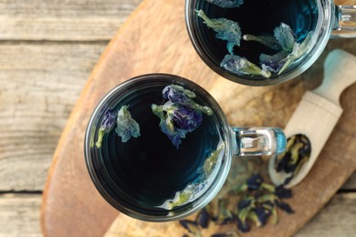 Photo of Delicious butterfly pea flower tea on wooden table, top view