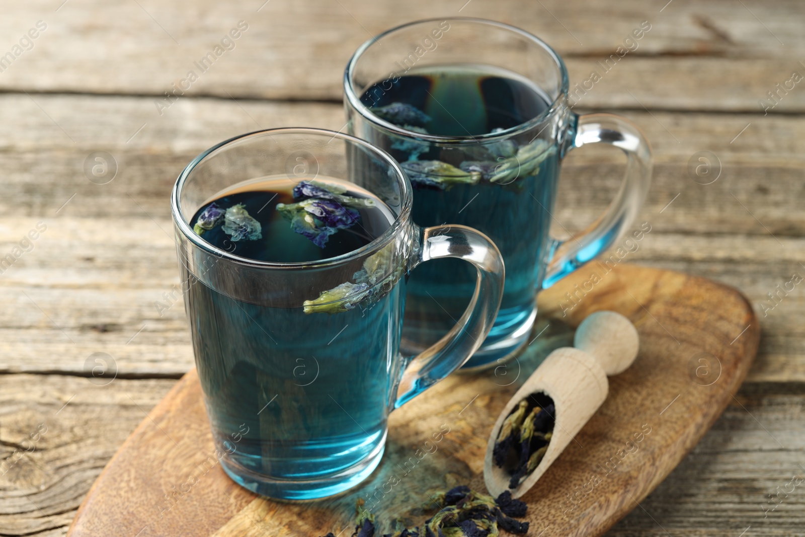 Photo of Delicious butterfly pea flower tea on wooden table, closeup