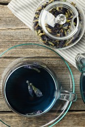 Photo of Delicious butterfly pea flower tea on wooden table, flat lay