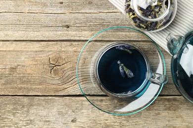 Photo of Delicious butterfly pea flower tea on wooden table, flat lay. Space for text