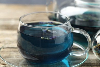 Photo of Delicious butterfly pea flower tea on wooden table, closeup