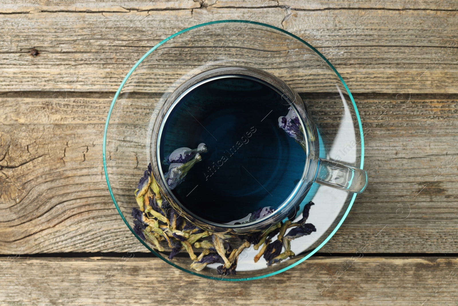 Photo of Delicious butterfly pea flower tea on wooden table, top view